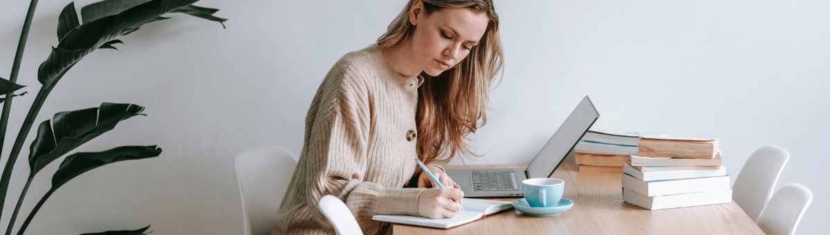 How Should a Goal Be Written? – A young woman working to write an IEP at her work desk.